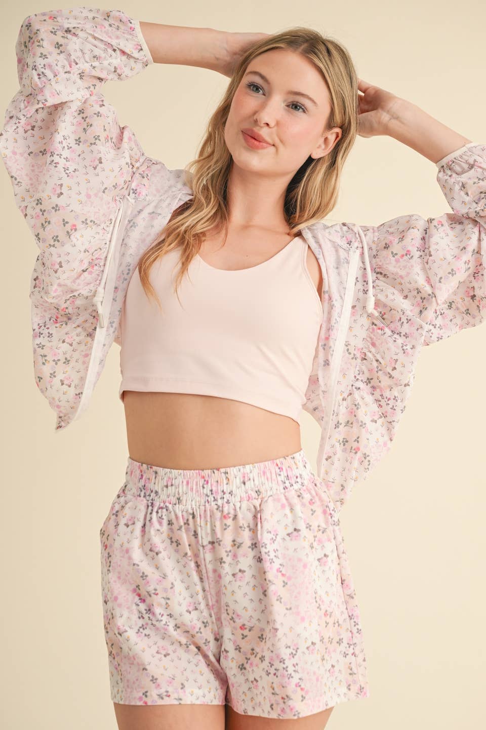 Woman wearing a floral kimono and shorts set on a beige background
