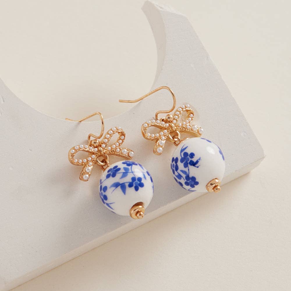 Round ceramic bead brass hook earrings by Designature New York featuring a stylish round-shaped ceramic bead and brass hook design.