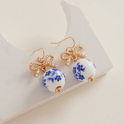 Round ceramic bead brass hook earrings by Designature New York featuring a stylish round-shaped ceramic bead and brass hook design.