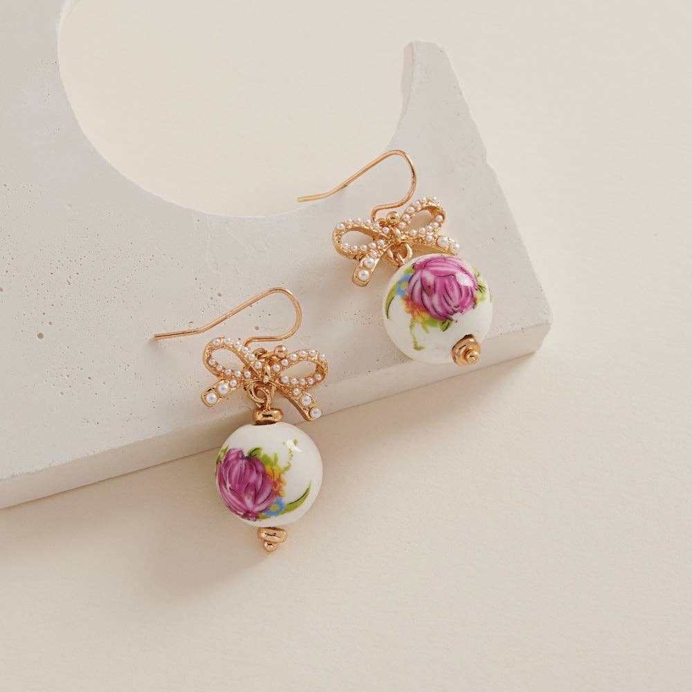 Round-shaped ceramic bead brass hook earrings by Designature New York featuring ceramic beads and brass hooks.